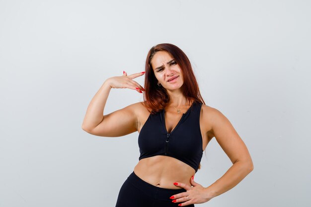 Young sporty woman with long hair in a black top