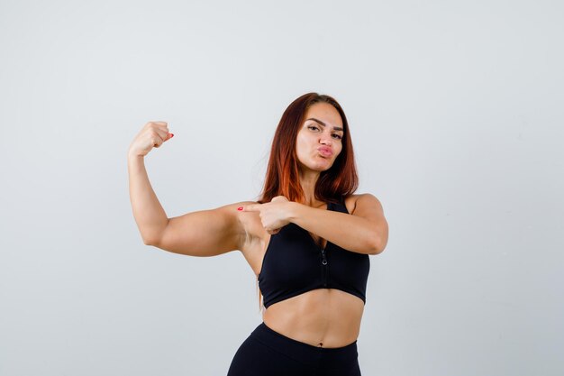 Young sporty woman with long hair in a black top