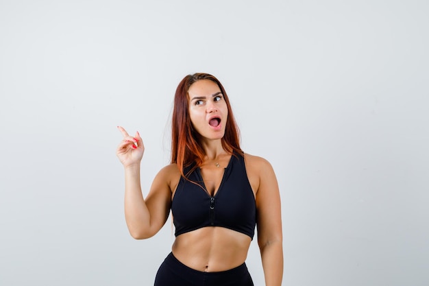 Young sporty woman with long hair in a black top