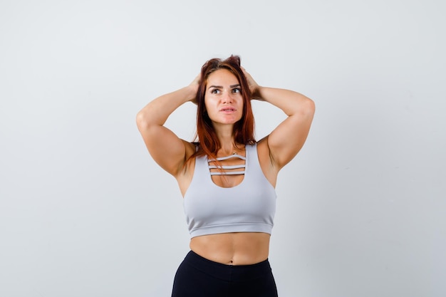 Young sporty woman with long hair in a gray top