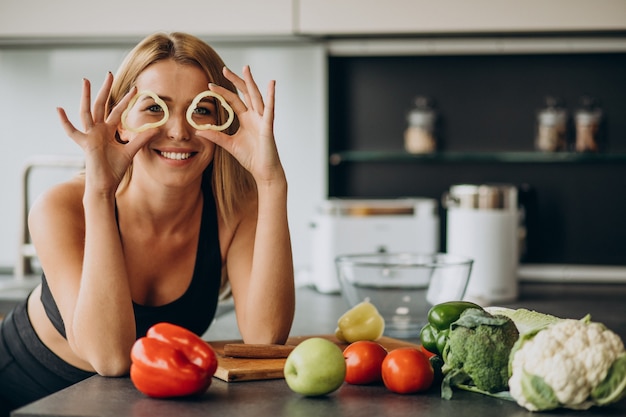 Free photo young sporty woman with pepper at the kitchen