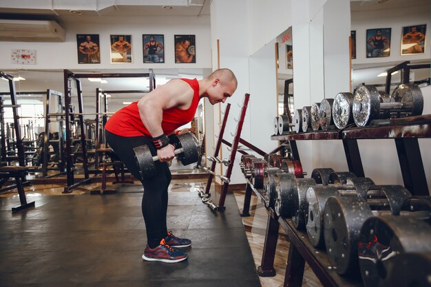 young and strong guy trains in the gym