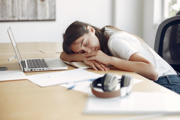 Free photo young student sitting at the table and sleeping