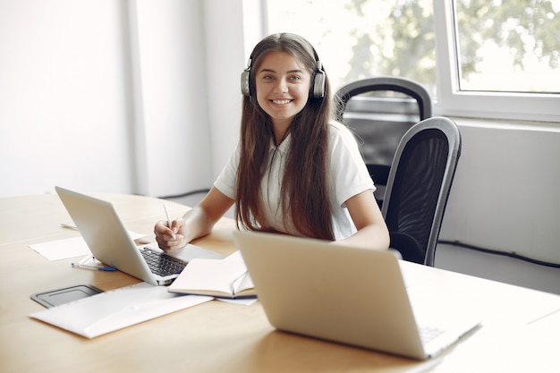 Young student sitting at the table and use the laptop