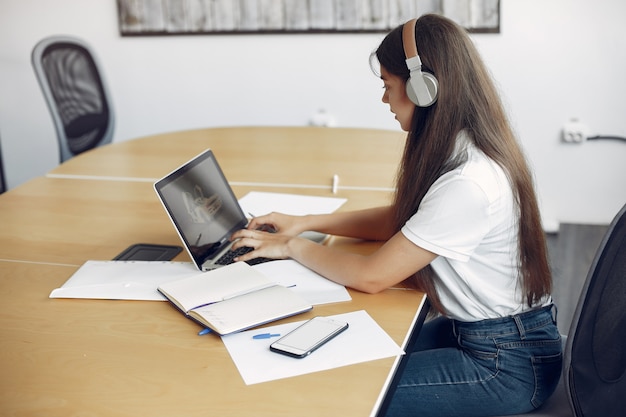 Young student sitting at the table and use the laptop