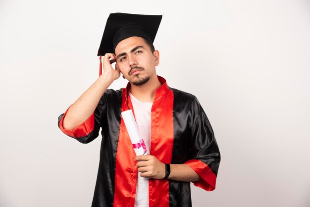 Young student with diploma thinking on white.