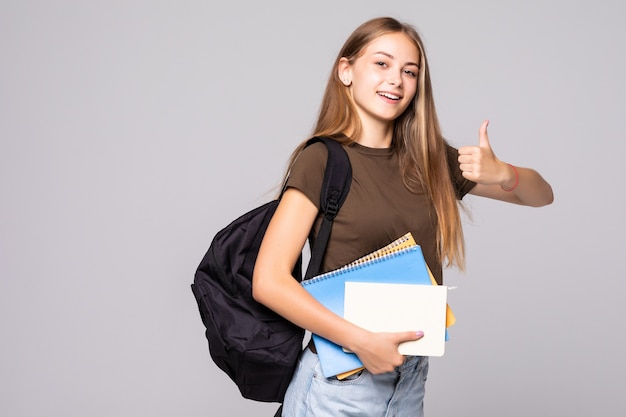 Young student woman with backpack bag holding hand with thumb up gesture, isolated over white wall