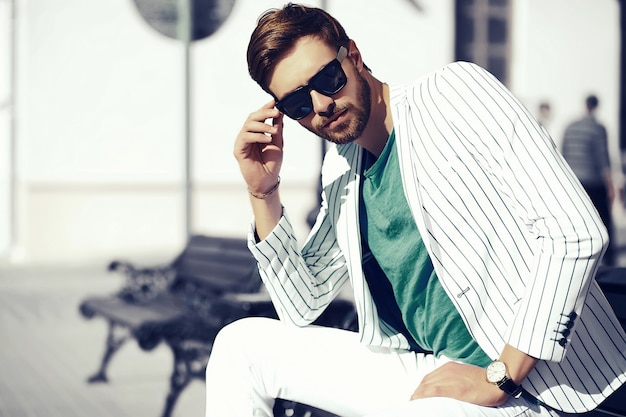 Free photo young stylish confident happy handsome businessman model  in suit cloth lifestyle in the street in sunglasses