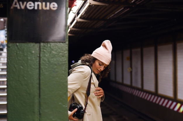 Young stylish female photographer exploring the subway in the city