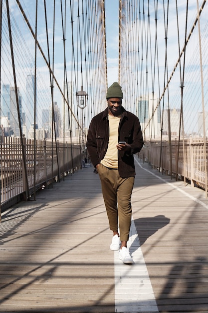 Young stylish man exploring a city bridge by himself