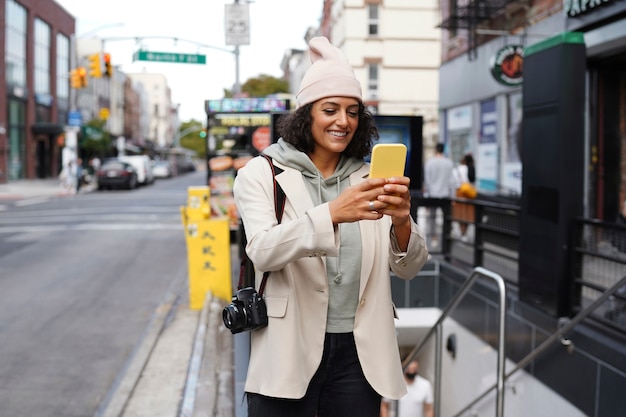 Free photo young stylish woman in the city using smartphone for exploration