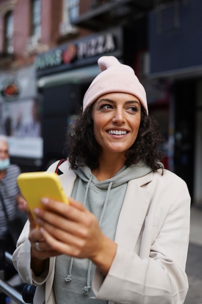 Young stylish woman in the city using smartphone for exploration