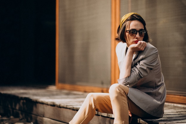 Young stylish woman sitting in the backyard