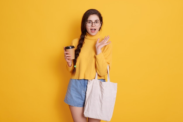 Free Photo young stylish young woman wearing shirt and short, lady holding bag and take away coffee