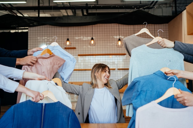 Young stylist looking through set of shirts for fashion shooting