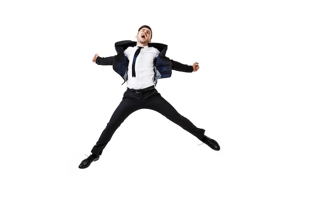 Free photo young successful businessman in suit rejoising, jumping on white