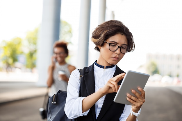 Young successful businesswoman looking at tablet over business centre.