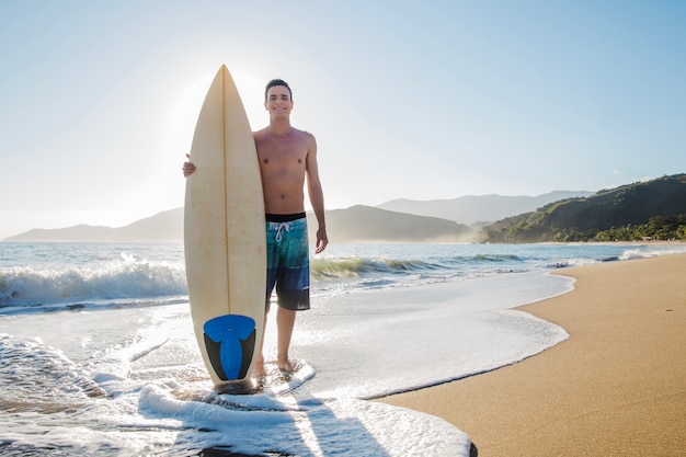 Free photo young surfer on the beach