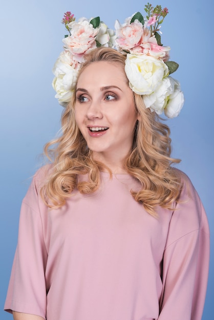 Free photo young surprised blond lady with beautiful flower wreath