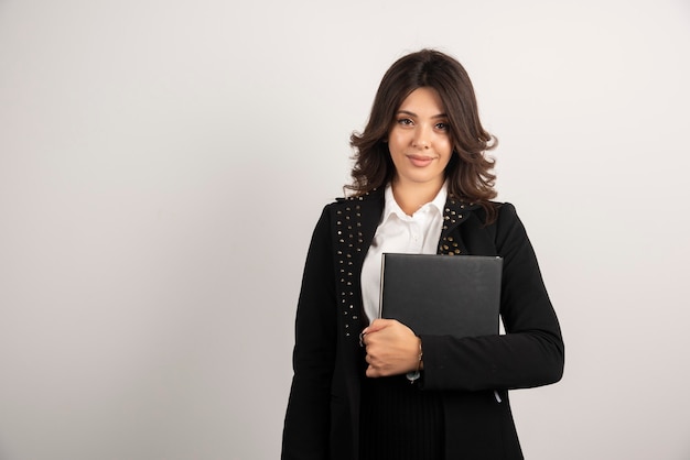 Young teacher holding book on white.