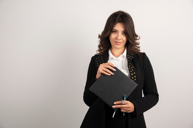 Young teacher posing with book on white.