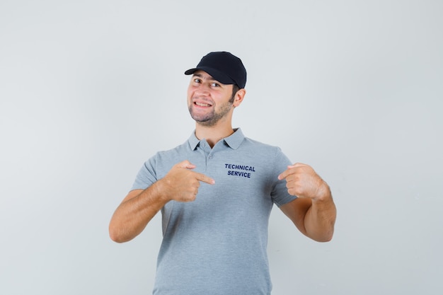 Free photo young technician pointing at his t-shirt in uniform and looking proud.