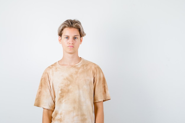 Free photo young teen boy looking at front in t-shirt and looking upset. front view.