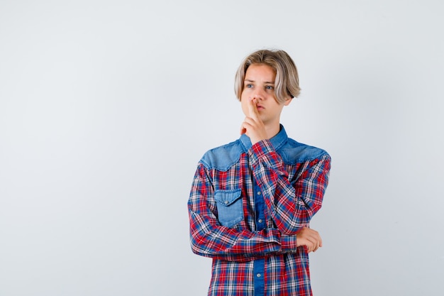 Free photo young teen boy with fingers in a gun gesture on mouth