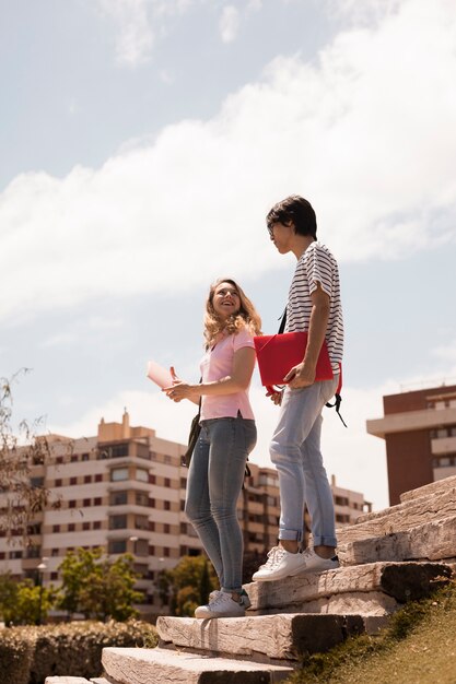 Young teen couple on stairs against cityscape