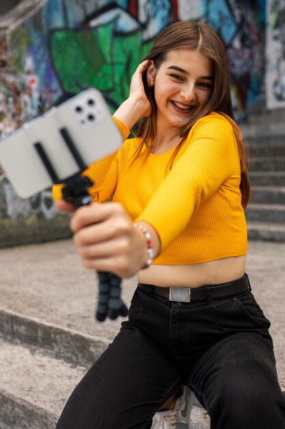 Young teenage girl recording reels of herself outdoors for social media