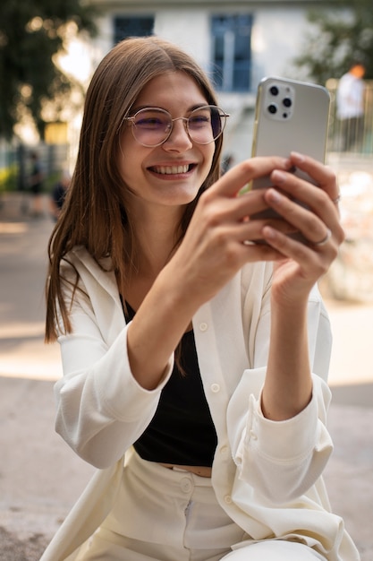 Young teenage girl recording reels of herself outdoors for social media