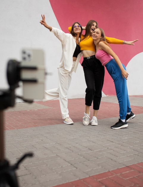 Free Photo young teenage girls recording reels of themselves outdoors for social media