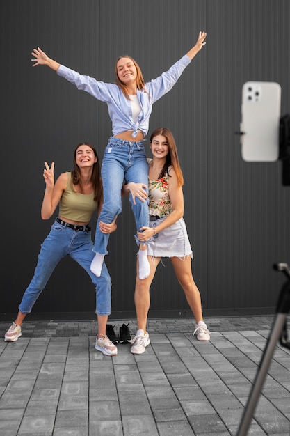 Free Photo young teenage girls recording reels of themselves outdoors for social media