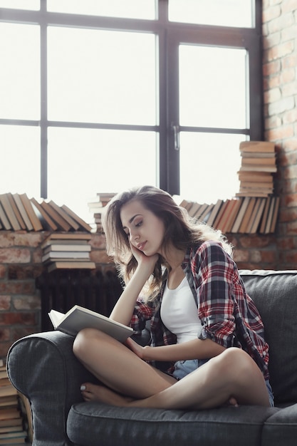 Young teenager girl reading a book at home