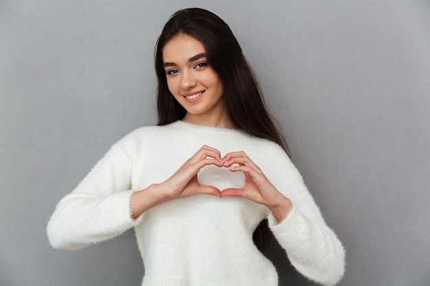 Young teenager woman doing heart gesture with hands