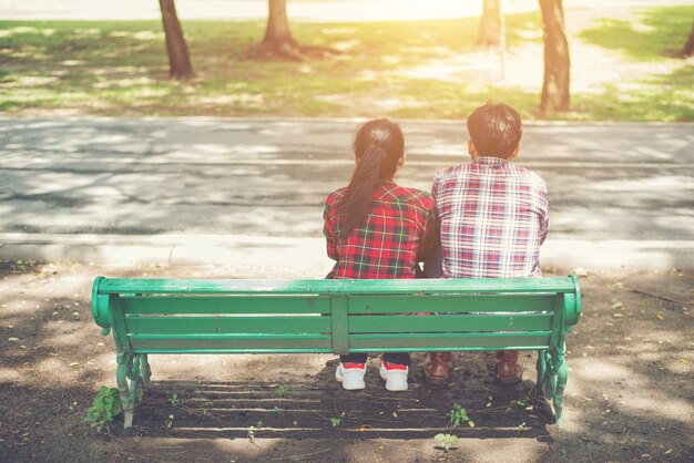 Young teenagers couple in love sitting together on the bench in