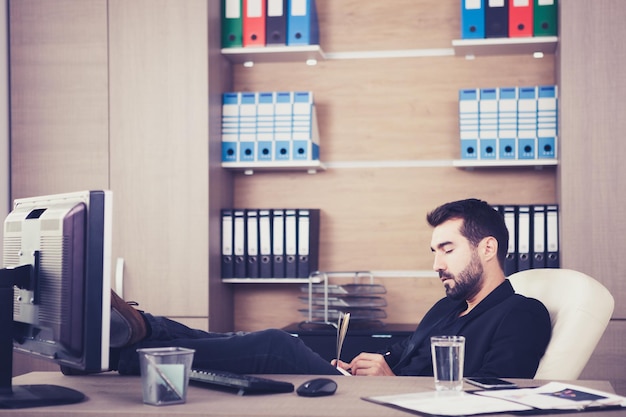 Free photo young tired businessman working in his office. businessperson in professional environment