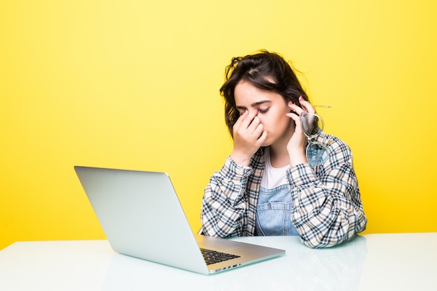 Young tired woman in front of a laptop isolated