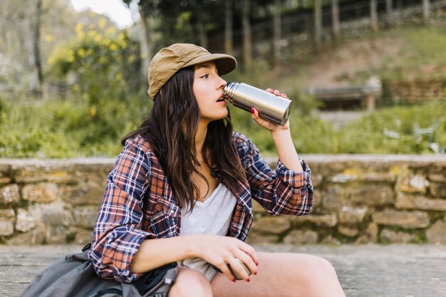 Young tourist drinking from thermos