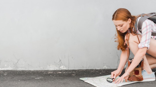 Free photo young traveler discovering map with loupe