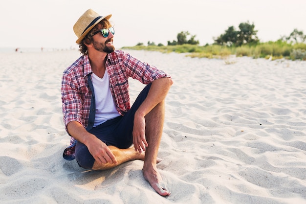 Free photo young traveler sitting on white sand