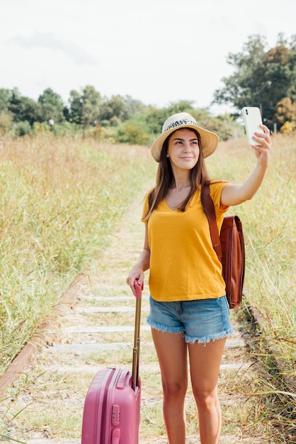 Young traveler with luggage taking a selfie