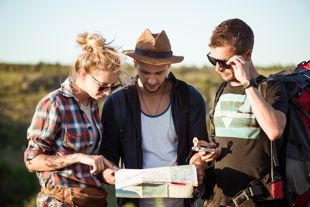 Free photo young travelers looking for route on map, walking in canyon