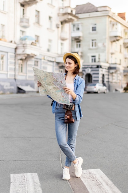 Young traveller with hat checking map