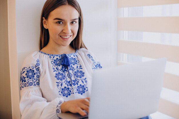 Young ukrainian woman wearing vyshyvanka working from home