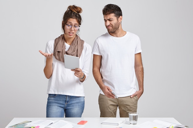 Young wife and husband stand at desk together