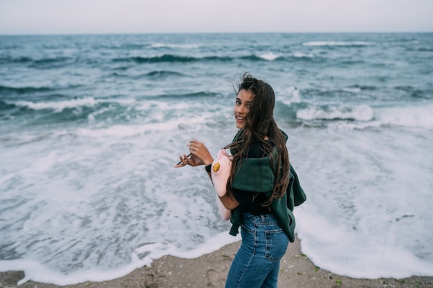 Young woma shoots on a smartphone the sea waves