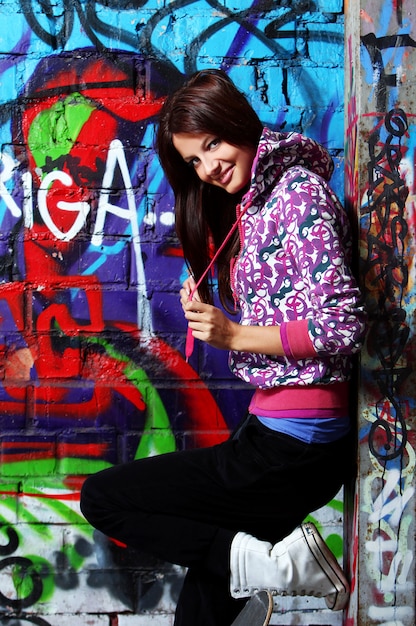 Young woman against wall with graffiti