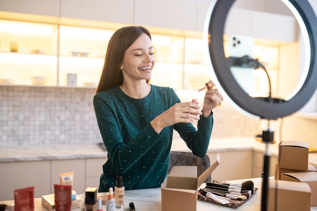 Young woman applying sample of new toning cream on her hand