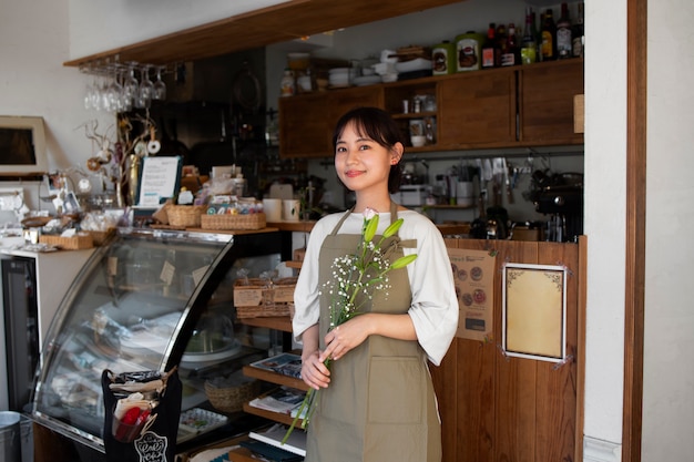 Free photo young woman arranging her cake shop